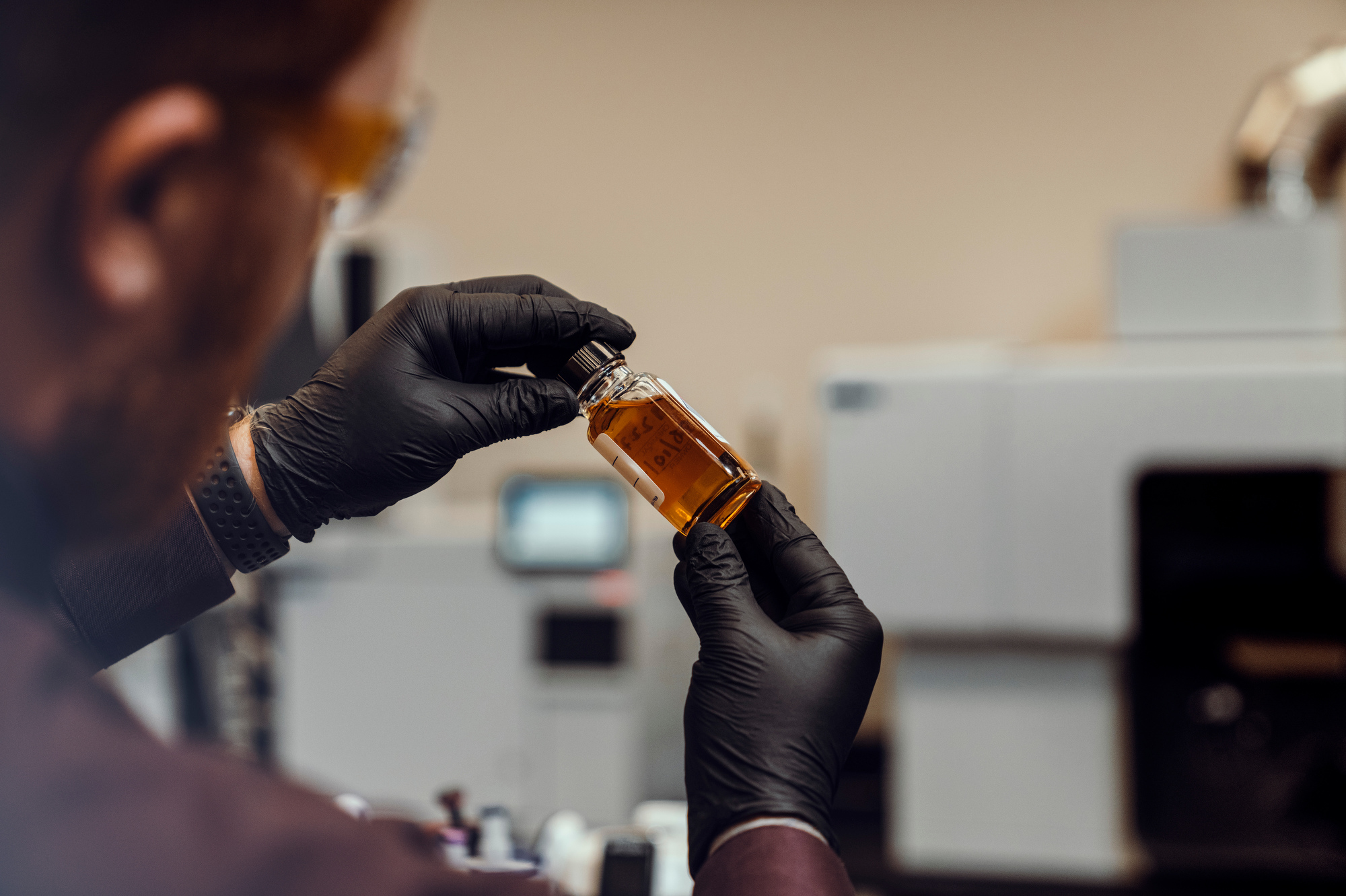 A chemist holding a chemical sample at a lab in Houston, Texas is photographed by Houston industrial photographer, Todd Spoth.