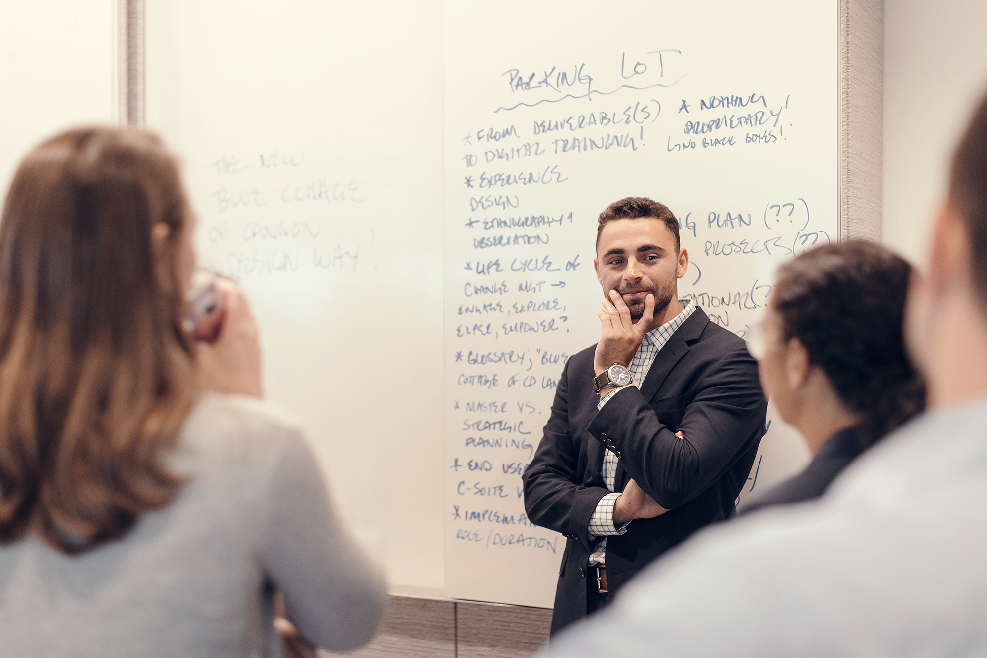 A corporate architectural design team has a meeting in front of a whiteboard, photographed by corporate photographer, Todd Spoth in Houston, Texas.