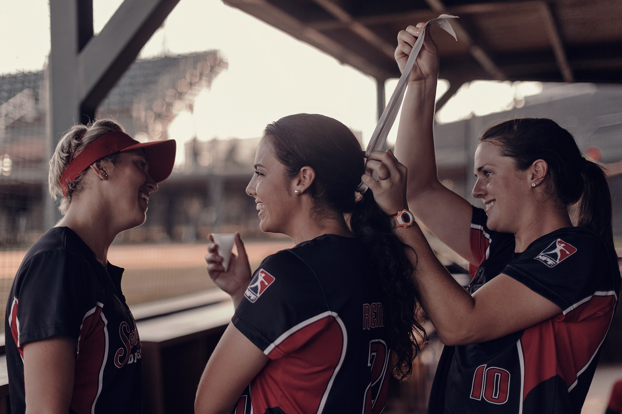 Teammates on the Scrap Yard Dawgs, a National Pro Fast Pitch softball team, photographed by lifestyle photographer, Todd Spoth, on location in Conroe, Texas.