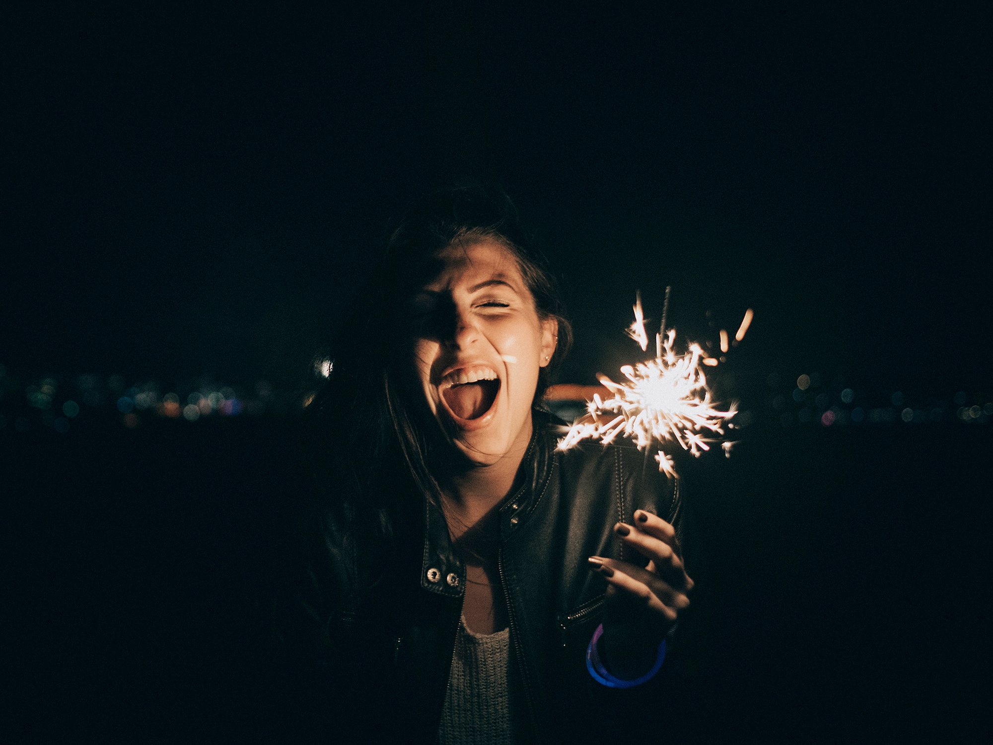 A girl holds a lit sparkler during a New Year