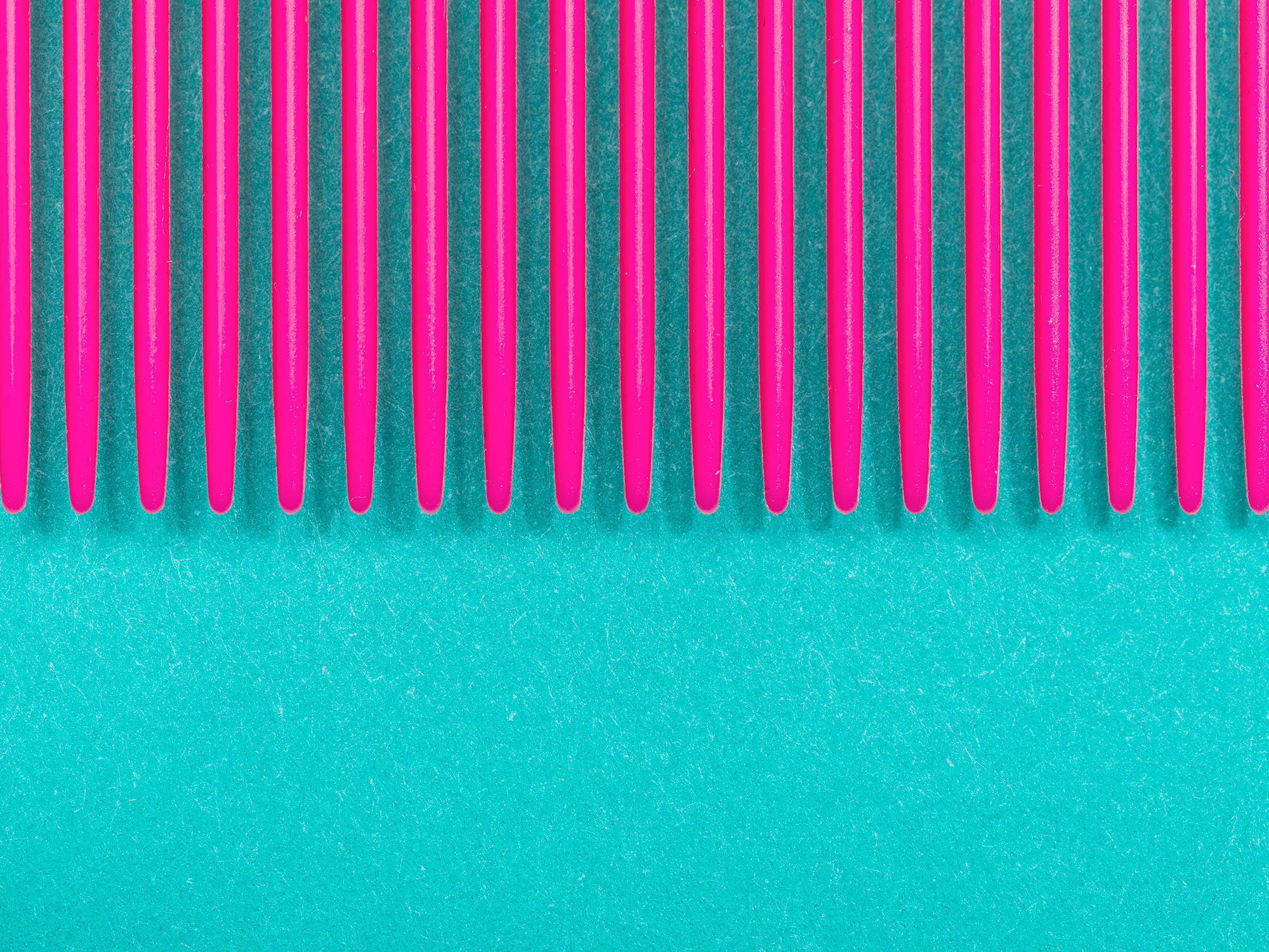 Detail photograph of a pink comb on teal paper, photographed by commercial photographer Todd Spoth.