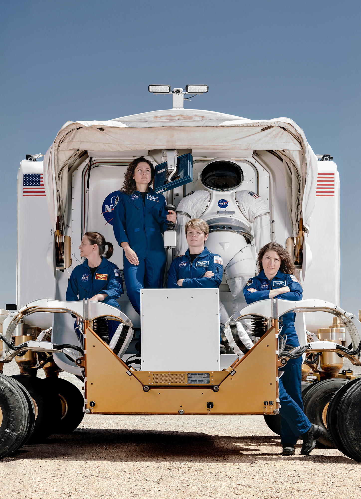 Christina Koch, Nicole Mann, Anne McClain and Jessica Meir, NASA astronauts, posed on the rear of the mars rover vehicle, photographed by Todd Spoth.